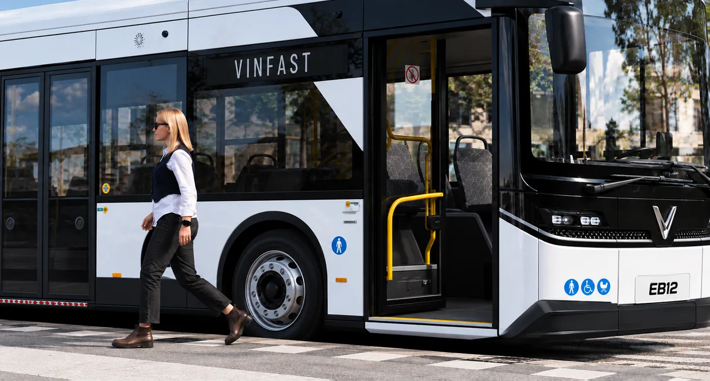 Passenger walking past the open front door of the VinFast EB12